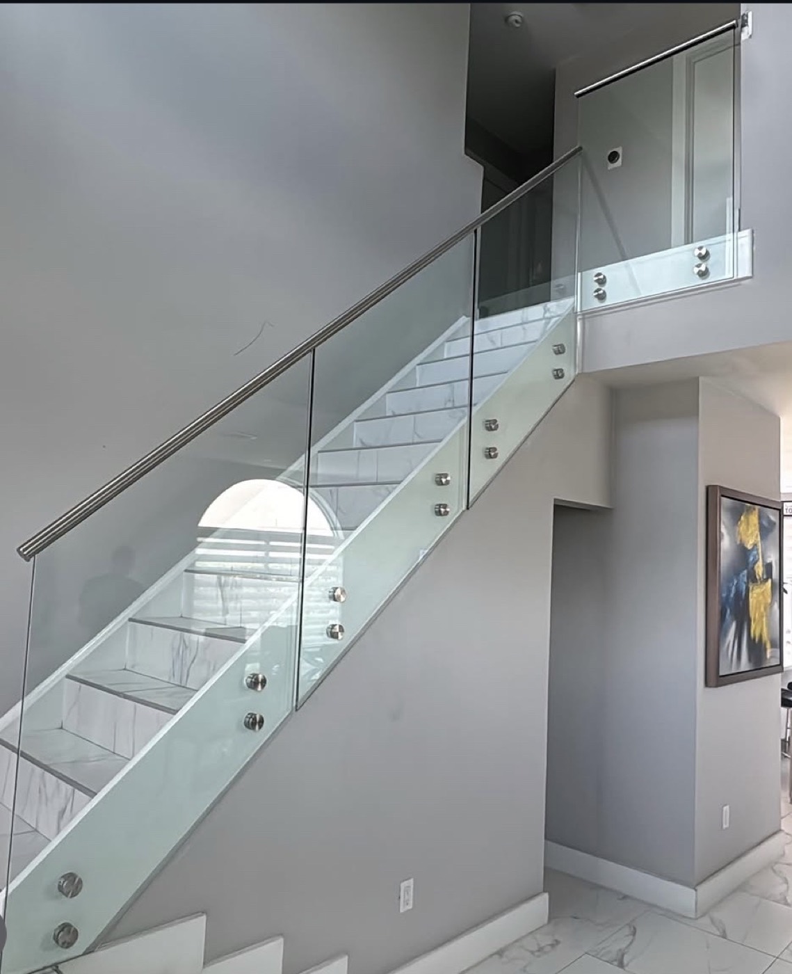 Frameless glass railing on a marble interior staircase